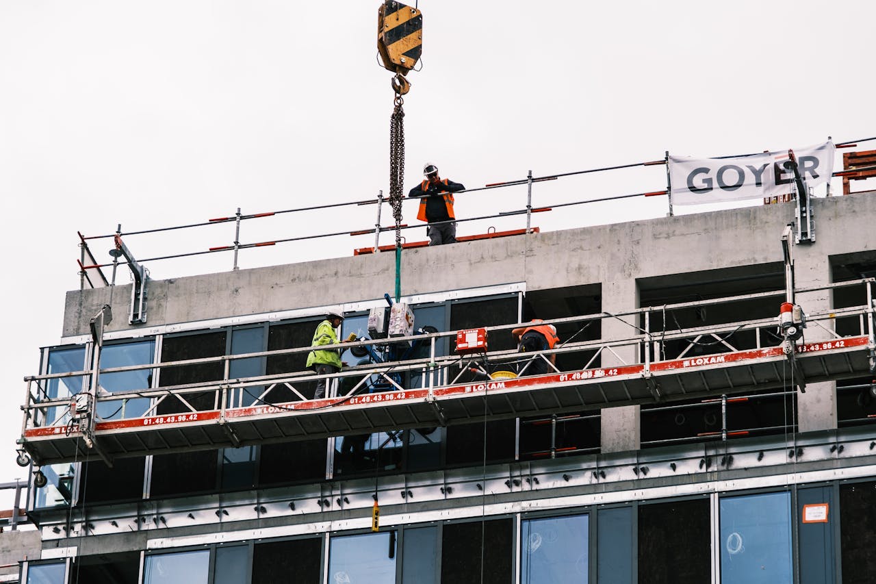 Professional workers at a construction site managing equipment on a high-rise building.